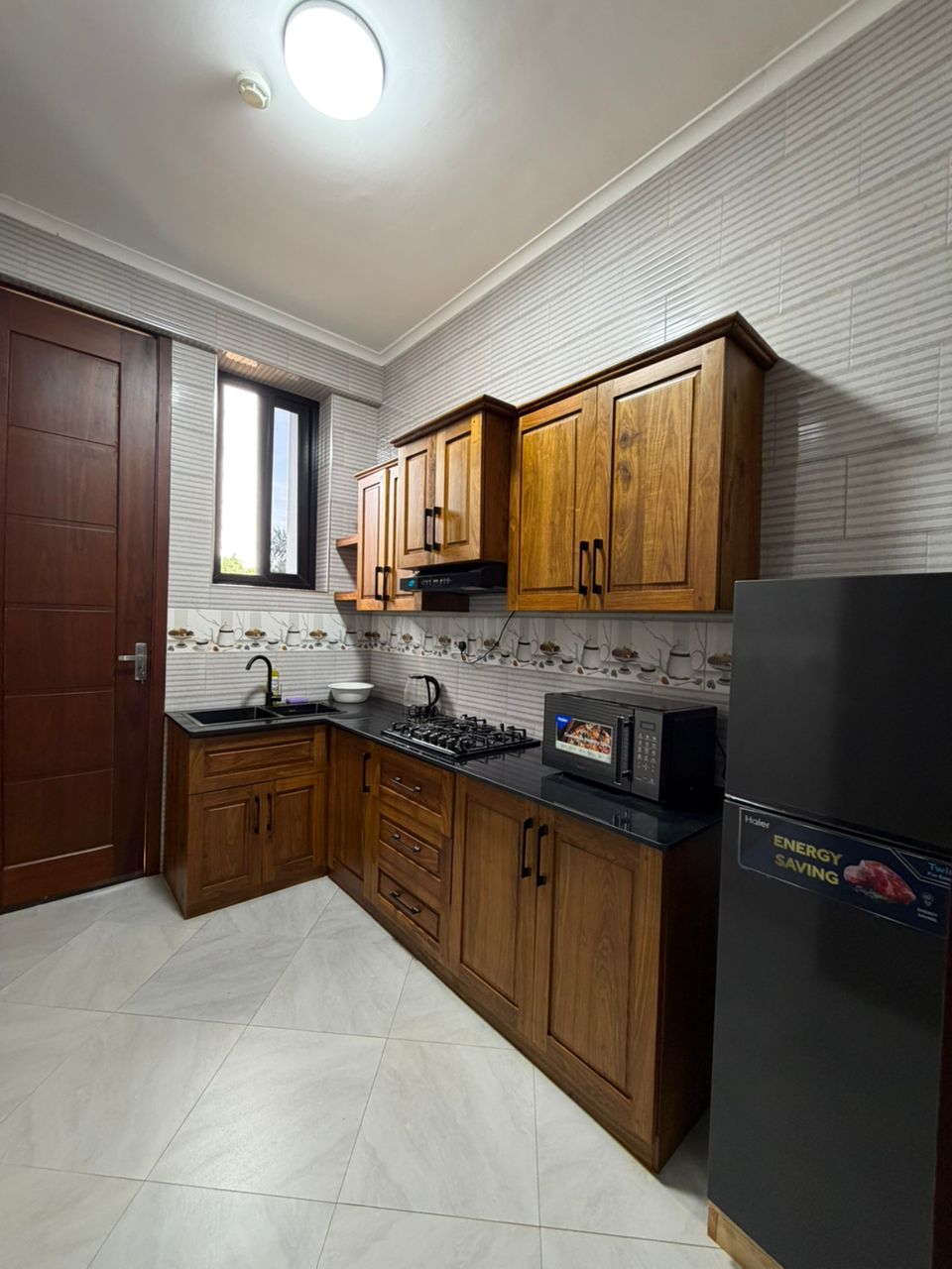 Double Hill Apartments fully equipped kitchen with solid wood cabinets, gas cooker, microwave and refrigerator